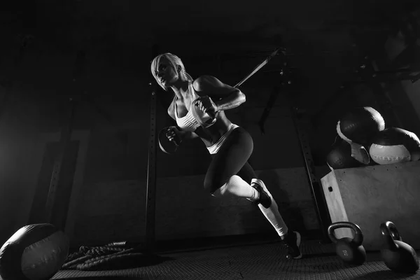 Женщина тренируется на TRX в тренажерном зале — стоковое фото