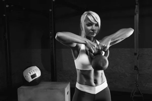 Muscular joven fitness mujer levantando un peso en el gimnasio —  Fotos de Stock