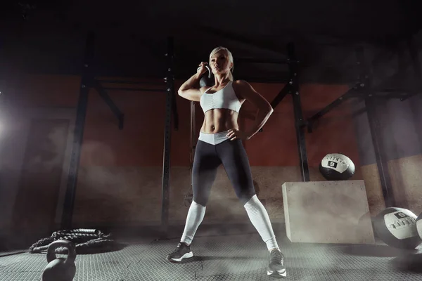 М'язиста молода фітнес-леді піднімає вагу в тренажерному залі — стокове фото