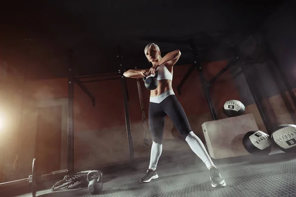 Muscular jovem mulher fitness levantando um peso no ginásio — Fotografia de Stock