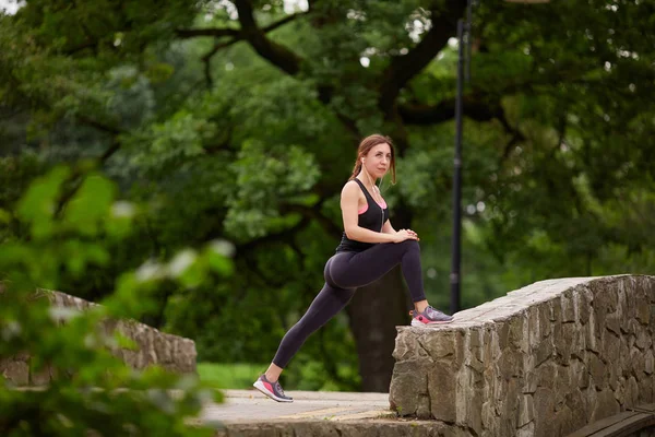 Chica estirándose en el parque — Foto de Stock