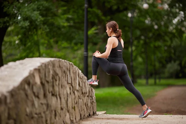 Garota se aquecendo antes do treinamento no parque — Fotografia de Stock