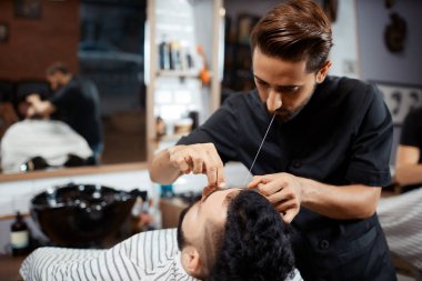 Profesyonel kuaför düzeltme iplik ile ekmek yapıyor.