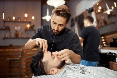 Berber dükkanında çalışan Kuaför ekmek beyaz iplik ile düzeltme.