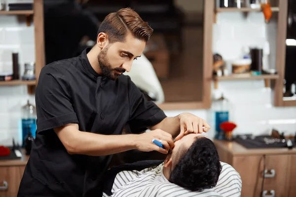 El estilista que corta el pan del cliente en el barbero moderno . — Foto de Stock