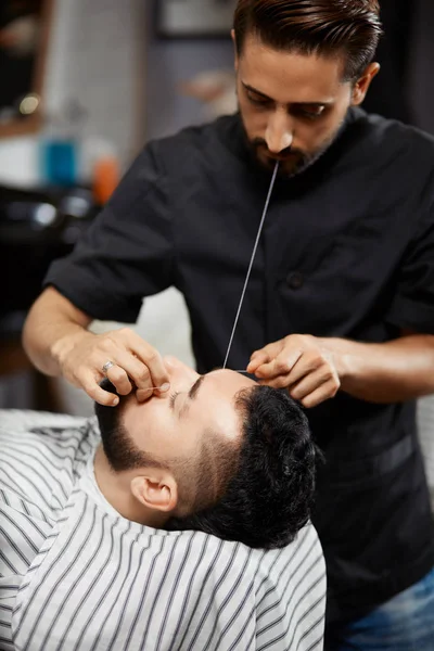 Professionell frisör gör korrigering av bröd i barbershop. — Stockfoto