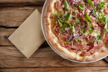 Süpürge, pastırma, peynir, salamura, kırmızı soğan ile İtalyan pizza.