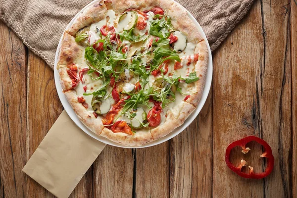 Gustosa pizza vegetariana con verdure, carta e basilico . Foto Stock