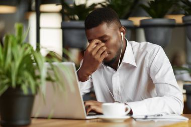 Sıkılmış Afrika adam karar sorun Café'de çalışma.