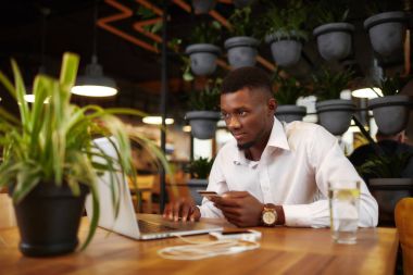 Afrika adam shoping kartı ve dizüstü bilgisayar ile internet dükkanında.