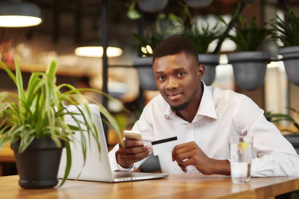 African man sending money with smart phone and laptop. — Stock Photo, Image