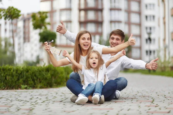 Família feliz na frente do novo prédio de apartamentos — Fotografia de Stock