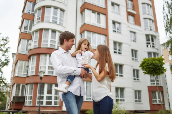 Happy family in front of new apartment building — Stock Photo, Image
