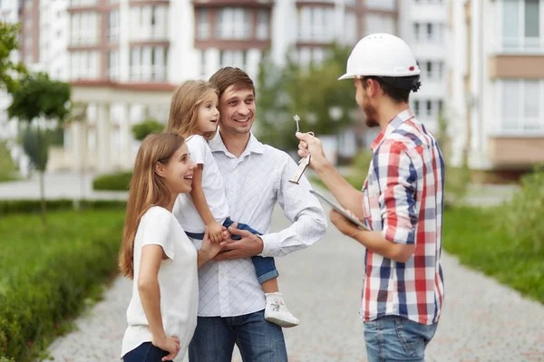 Happy family in front of new apartment building — Stock Photo, Image