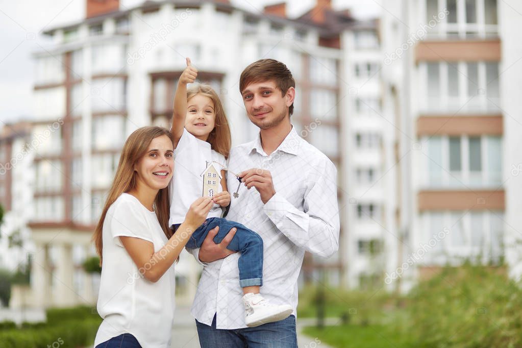 Happy family in front of new apartment building