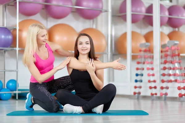 Mujer joven haciendo ejercicio con su instructor de fitness —  Fotos de Stock