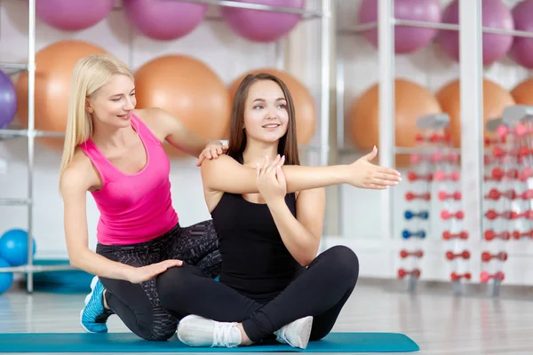 Jovem mulher se exercitando com seu instrutor de fitness — Fotografia de Stock