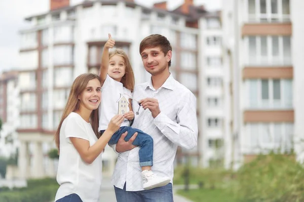 Família feliz na frente do novo prédio de apartamentos — Fotografia de Stock