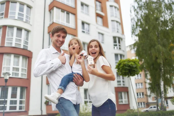 Happy family in front of new apartment building — Stock Photo, Image