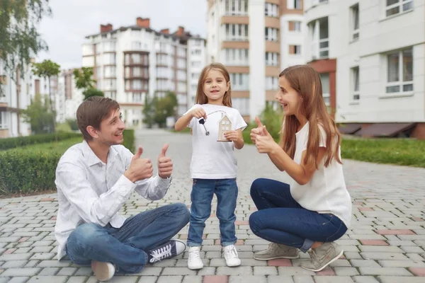 Família feliz na frente do novo prédio de apartamentos — Fotografia de Stock