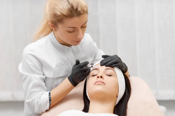 Cosmetologist fazendo procedimento de beleza para o paciente . — Fotografia de Stock