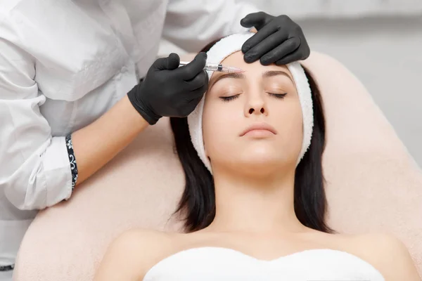 Cosmetology especialista dando injeção de elevação para mulher bonita . — Fotografia de Stock