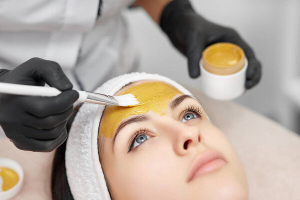 Gorgeous woman enjoying mask procedures in beauty salon.
