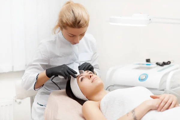 Cosmetólogo haciendo ultrasonidos faciales en salón de belleza . — Foto de Stock