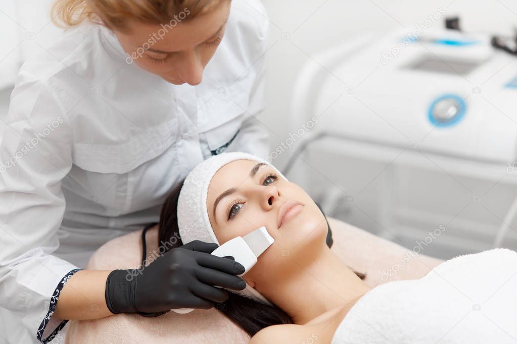 Beauty salon procedures of ultrasonic cleaning of face.