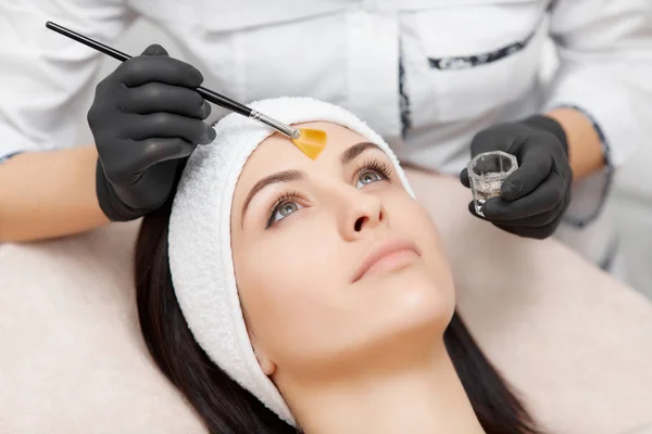 Beautiful woman getting facial peeling mask in beauty salon. — Stock Photo, Image