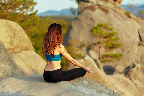 Mladá žena cvičit jógu venku — Stock fotografie