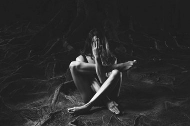 Dışarıda yoga yapan genç bir kadın.