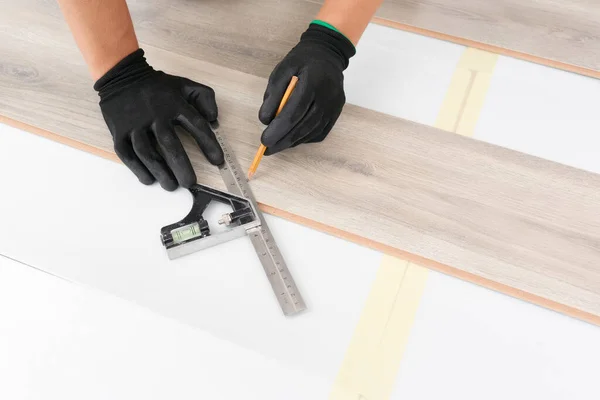 Manos obreras instalando suelo laminado de madera . —  Fotos de Stock