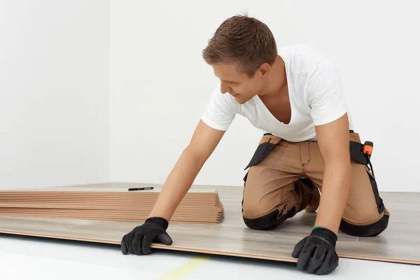 Hombre instalación de pisos laminados de madera nueva —  Fotos de Stock