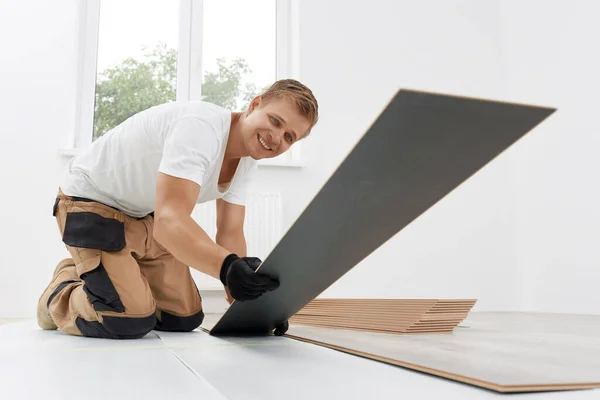 Trabajador masculino instalando pisos laminados —  Fotos de Stock