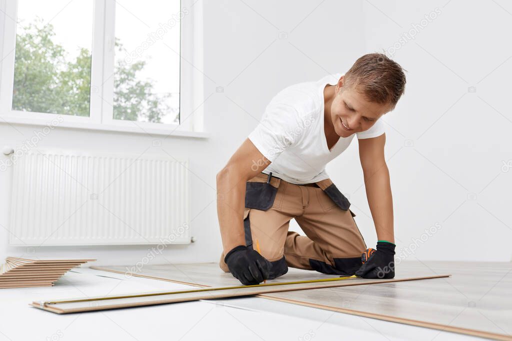 Man installing new wooden laminate flooring