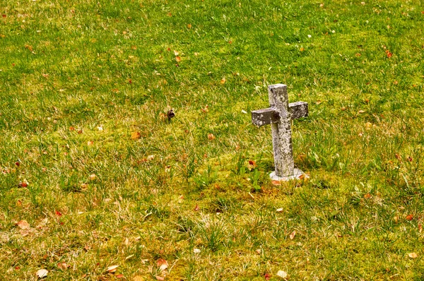 Cruz de pedra na grama — Fotografia de Stock