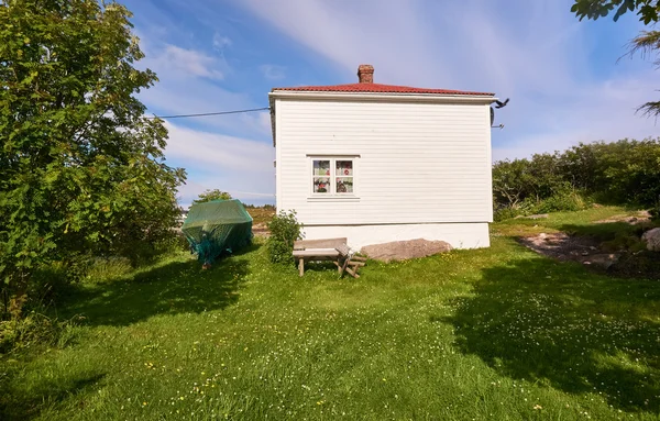 Vita fisherman's house, i trädgård täckt båt — Stockfoto