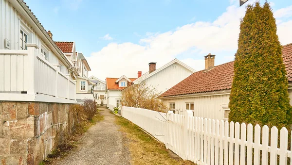 A nostalgic Norwegian alley, a wooden fence in front of white ho — Stock Photo, Image