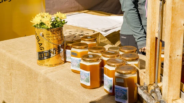 Frascos con productos de panal y velas de gelatina de abeja — Foto de Stock