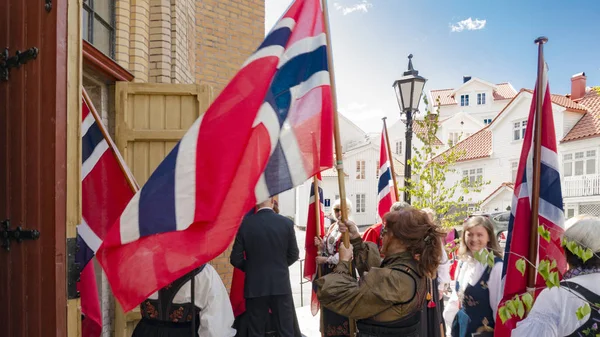 Норвежцы перед церковью между национальными флагами — стоковое фото