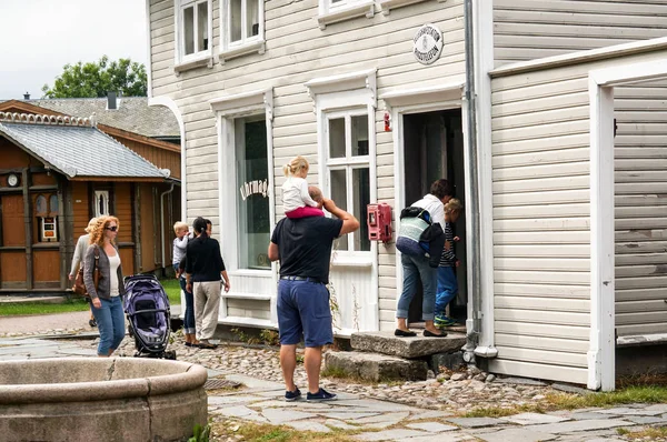 Turistas em frente a uma casa de madeira histórica branca — Fotografia de Stock