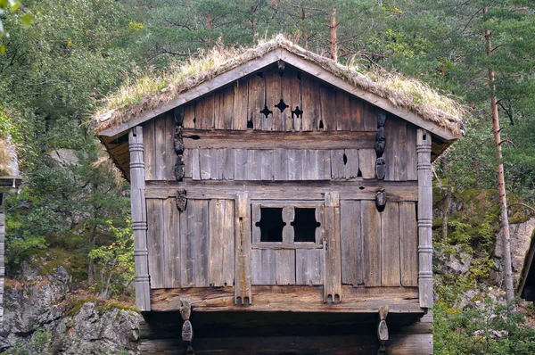Antiguo edificio de la granja para almacenar alimentos, troncos de madera, techo verde — Foto de Stock