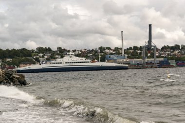 Moss Rygge, Norveç - 17 Eylül 2017: Moss kasabası, endüstriyel mirasa sahip çevre bölgeler, gelişen bir sanat sahnesi ve plajlar. Kumlu bir plaj. Körfezde gemiler ve feribotlar. Rüzgarlı gün. Geleneksel ahşap binalar. Küçük kırmızı ahşap 