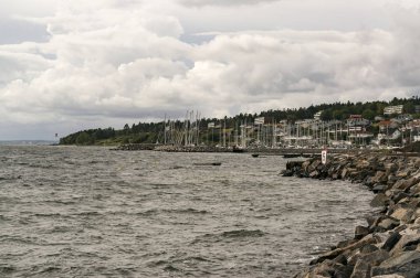 Moss Rygge, Norveç - 17 Eylül 2017: Moss kasabası, endüstriyel mirasa sahip çevre bölgeler, gelişen bir sanat sahnesi ve plajlar. Kumlu bir plaj. Körfezde gemiler ve feribotlar. Rüzgarlı gün. Geleneksel ahşap binalar. Küçük kırmızı ahşap 