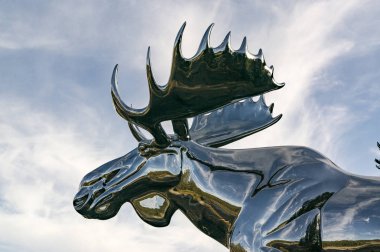 Osterdalen, Norveç - 17 Eylül 2017: Ormanda, gökyüzüne karşı bir Norveç geyiği heykeli. Gümüş dev geyik. 10 metre yüksekliğinde ve 12 metre uzunluğunda. Yazar Linda Bakke olduğunu.