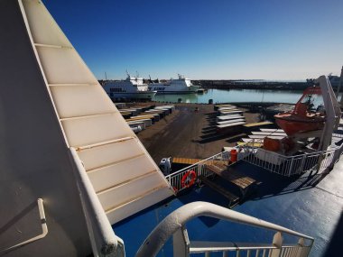 Trelleborg, İsveç - 14 Mart 2020: İsveç liman rıhtımının manzarası. Nakliye yarı römorkları feribota yüklenmeyi bekliyor. Renkli kamyonlar, yüksek liman binaları. Paskalyadan Önce Hareket