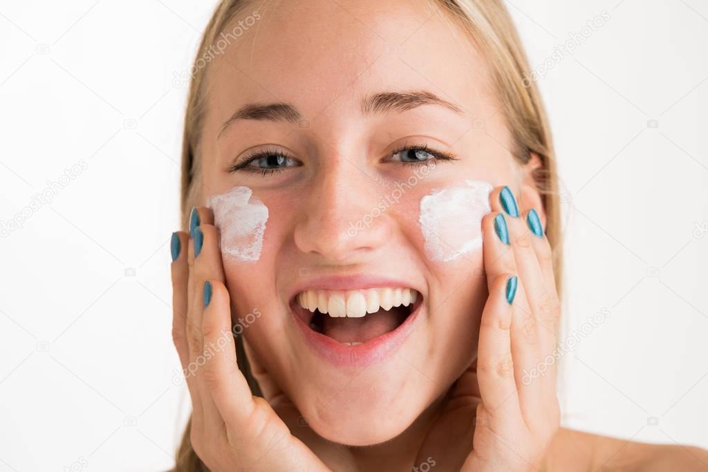 girl using care skin products on face