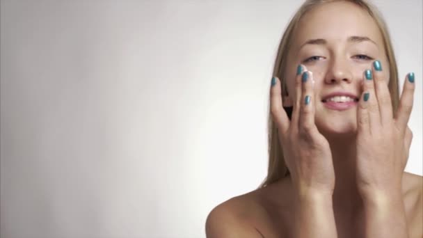 Fille en utilisant des produits de soins de la peau sur le visage — Video