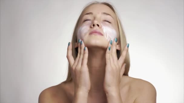 Fille en utilisant des produits de soins de la peau sur le visage — Video